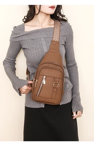 Brown faux leather crossbody bag with textured pebble finish and chic woven strap