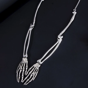 Detailed view of silver skeleton hand necklace pendant with a gothic bone structure