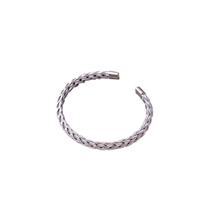 Minimalist silver braided knot open bangle with polished metallic finish and textured surface