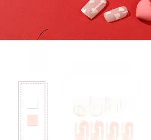 Close-up of pink press-on nails with white heart patterns and cloud texture details
