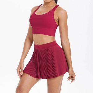 Detail of dark red sports set showing the pleated tennis skirt and elastic crop top