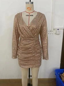 Detailed view of long sleeve gold sequin mini dress with deep V-neck and ruched texture