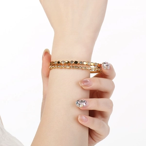 Detail of two 18K gold plated stainless steel bangles with sparkling white cubic zirconia
