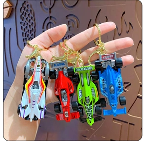 Close-up of four colorful mini F1 racing car keychains in white, red, green and blue