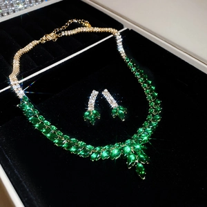 Close-up of zircon wheat tassel jewelry set featuring green gems in a black gift box