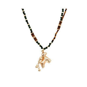 Collier avec pendentif caniche doré et perles de verre oeil de tigre sur fond blanc