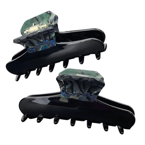 Macro detail of glossy black hair claws with green marble inlay and strong metal spring