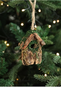 Détail d'un nichoir décoratif en écorce et mousse sur un sapin de Noël festif