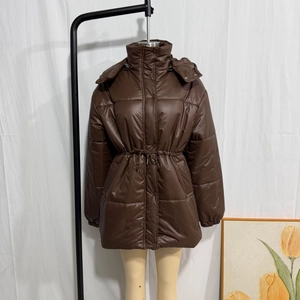 Detail of dark brown drawstring waist on shiny padded jacket with quilted texture