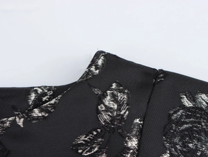 Close-up of black rose jacquard fabric with metallic silver floral pattern detail
