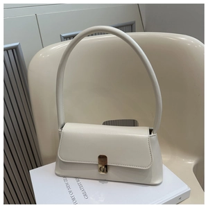 Detail of cream baguette bag with gold square twist lock on a minimalist leather flap