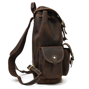 Side view of dark brown crazy horse leather backpack showing side pockets and stitching
