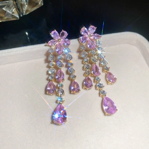 Close-up of pink zircon flower earrings with long hanging crystal tassels in gold finish
