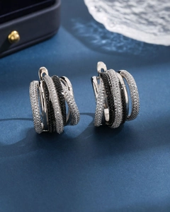 Macro shot of multi-layer silver earrings with sparkling black and white zircon stones