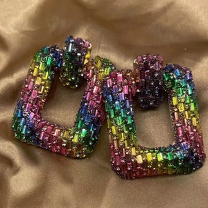 Macro detail of oversized square earrings with colorful gradient rainbow rhinestones