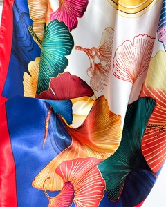 Close-up of smooth satin scarf with ginkgo leaf patterns in vibrant multi-color silk fabric