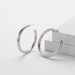 Detailweergave van glanzende S925 sterling zilveren C-vormige oorringen op witte blokken