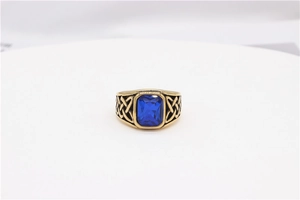 Macro shot of Viking style gold titanium ring with blue gem and Celtic knot details