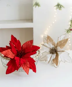 Close-up of velvet poinsettia flowers with red and gold glitter for Christmas decor