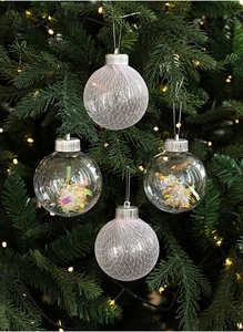 Detail of mesh wrapped and sequin filled Christmas ornaments on a festive pine tree