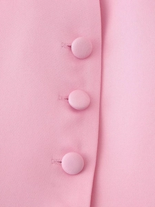 Dettaglio della trama del tessuto rosa e tre bottoni rivestiti coordinati sul blazer