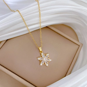 Elegante collana con ciondolo a fiocco di neve in oro e cristalli su una scatola
