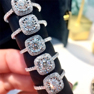 Set of luxury round-cut bridal rings with halo setting and pavé diamonds in silver