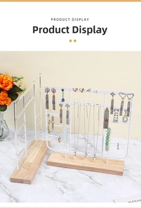 Metal jewelry display stand with wooden base for necklaces and earrings, closeup view