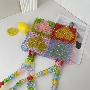 Close-up of colorful acrylic beaded tote bag with summer lemon props on white background