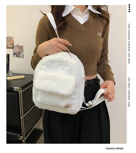 Primer plano de mini mochila de felpa blanca con piel sintética suave y correas ajustables