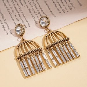 Macro detail of vintage gold fringe earrings with clear crystals and arched metal tassel