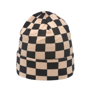 Close-up detail of knitted checkerboard pattern texture and folded cuff on beanie