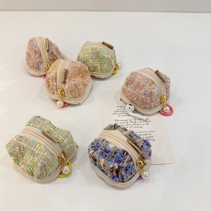 Vista dettagliata di varie mini pochette in tweed a quadri per auricolari wireless