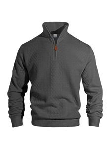 Close-up of grey jacquard knit sweater showing metal half-zip and stand collar texture