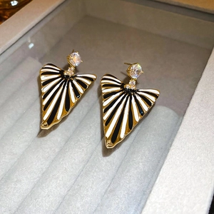 Vue macro de boucles d'oreilles rétro avec rayures noir et blanc et bord doré