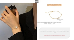 Detail view of gold bracelet with round white drip oil star pendant and tiny cross charms