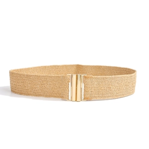 Detail of woven straw elastic belt in beige with a round gold metal buckle on white background