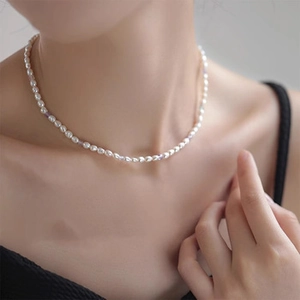 Detail of freshwater pearl necklace with purple accents on a model neck