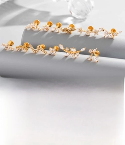 Detailed macro view of titanium steel stud jewelry with zirconia star and leaf designs