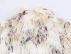 Detailed macro view of soft faux fur fabric with beige and brown leopard print pattern