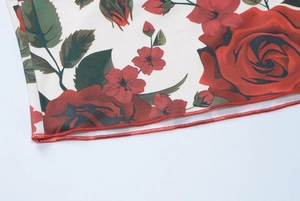 Detailed close-up of floral print fabric with red hem stitching on a summer dress