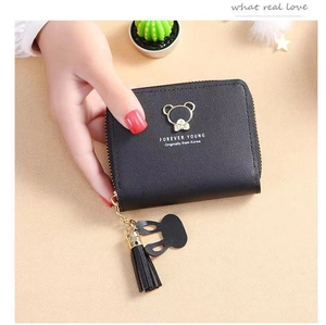Close-up of black leather wallet featuring a golden bear logo and stylish tassel charm