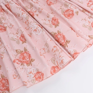 Détail de l'imprimé floral rose sur tissu mousseline avec ourlet de robe plissé délicat