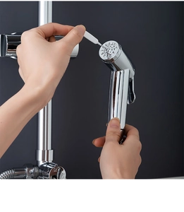 Macro shot of hand using a mini white brush to clean nozzle holes on a chrome shower head