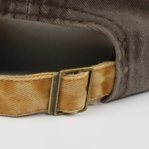 Macro detail of the adjustable bronze metal buckle on the washed cotton baseball cap