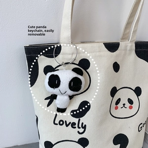 Detailansicht eines süßen abnehmbaren Plüsch-Panda-Anhängers an einer Canvas-Tasche