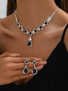 Close-up of elegant black teardrop crystal bridal necklace and earrings set on model