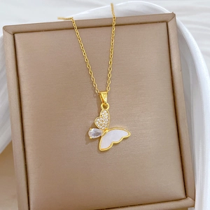 Detail shot of golden butterfly pendant with shell wing and sparkling zircon crystals