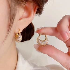 Macro shot of U-shaped gold earrings with micro-pave cubic zirconia crystals