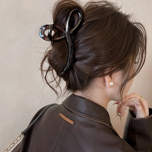 Detail view of a tortoiseshell claw clip securing a chic bun hairstyle on a woman